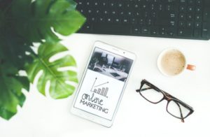 image of laptop, glasses, and phone with online marketing for digital marketing budget allocation tips